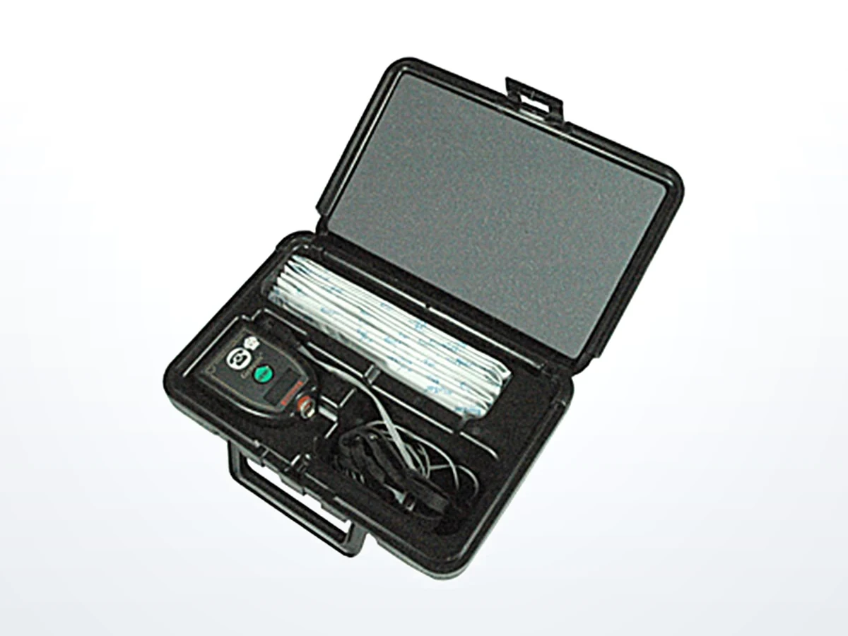 An open carrying case holding a hand-held instrument, cable and accessories with a foam lid pad